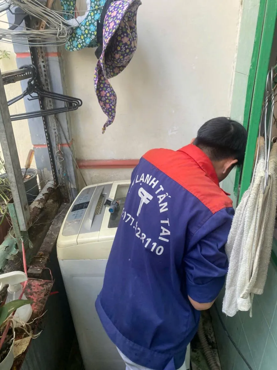 Hình ảnh kỹ thuật viên đang sửa máy giặt