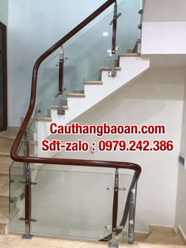 Tay vịn gỗ kết hợp lan can kính trên bậc thang đá đen, gầm cầu thang làm tiểu cảnh xanh