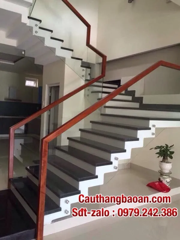 Mẫu tay vịn cầu thang gỗ uốn cong kết hợp lan can kính cường lực sang trọng