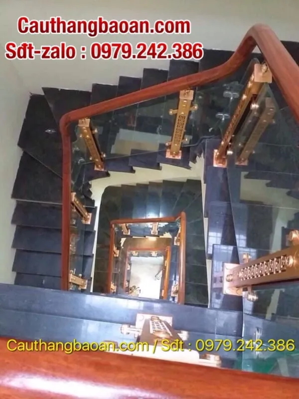 Cầu thang xoắn ốc lan can kính tay vịn inox sáng bóng trong không gian hiện đại
